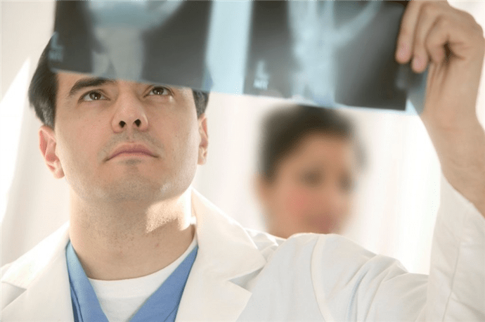 lékař zkoumá obraz kyčelního kloubu s artrózou